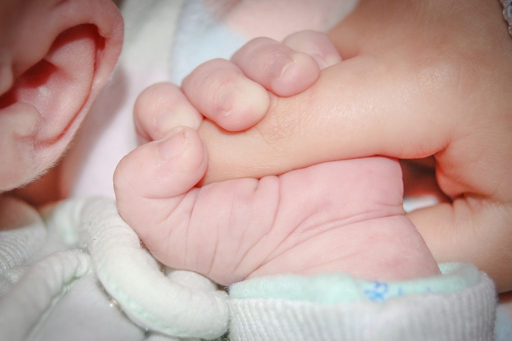 un enfant tient un doigt